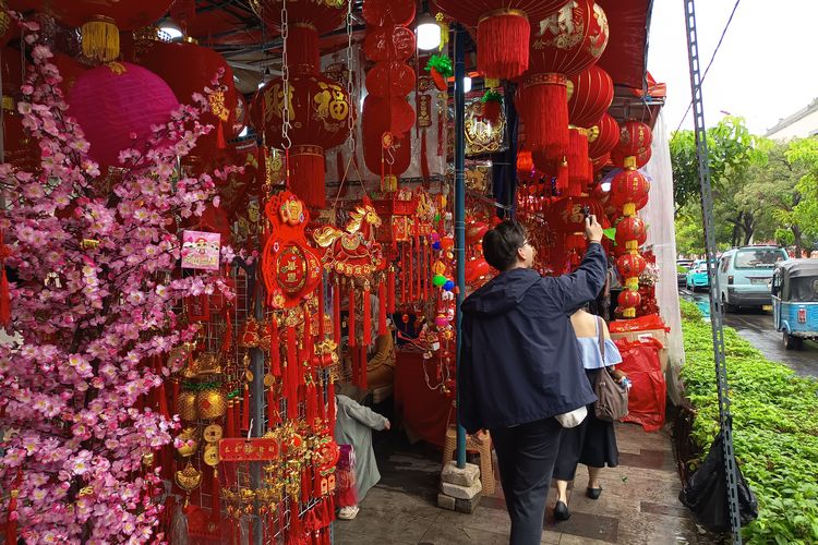 Pedagang ornamen imlek menata barang dagangannya di kawasan Glodok Pancoran Chinatown, Mingu (1/2/2026).