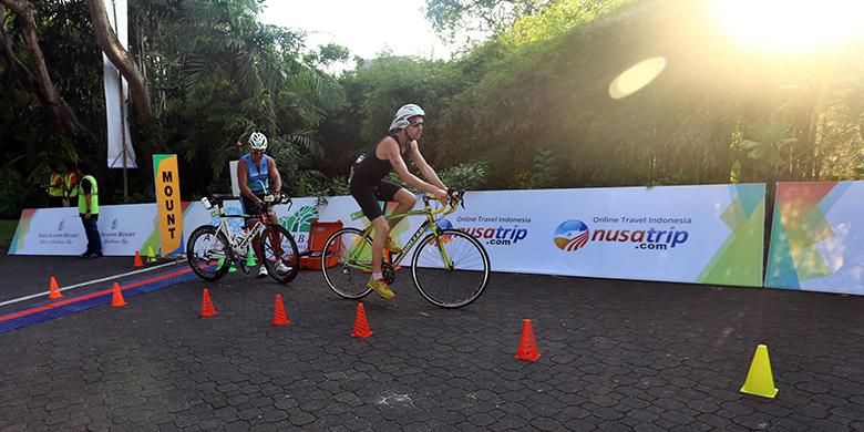 Peserta Herbalife Bali International Triathlon (HBIT) 2015 bersepeda usai melakukan sesi renang di kawasan Pantai Jimbaran, Bali, Minggu (25/10/2015).