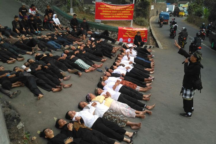 Puluhan warga adat Karuhun Urang Sunda Wiwitan Cigugur melakukan aksi tidur di jalan menuju lokasi eksekusi, di Desa Cigugur, Kecamatan Cigugur, Kabupaten Kuningan, Jawa Barat, Kamis pagi (24/8/2017).