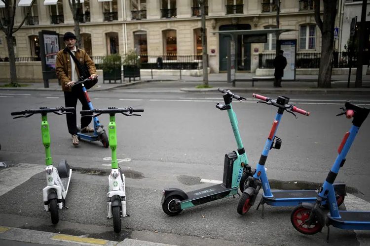 Seorang laki-laki menaiki skuter listrik di Paris, Perancis, Jumat (31/3/2023). 