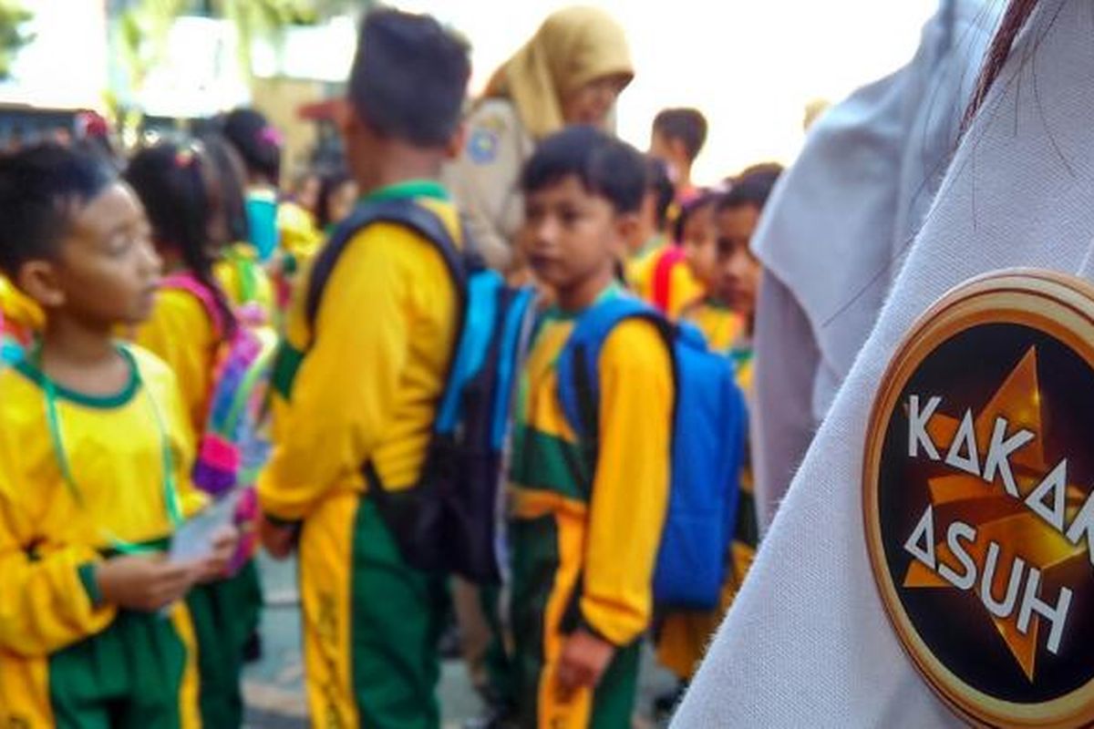 Mengenakan selendang songket dan PIN, kakak asuh SDN 2 Cakranegara menemani murid baru di hari pertama sekolah.