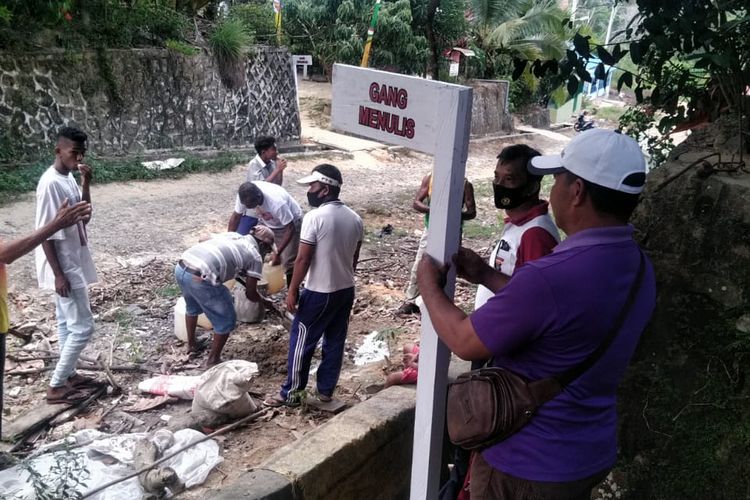 Sejumlah masyarakat kampung Timur Nunukan gotong royong masang plang nama gang kampung bernuansa pendidikan untuk mengingatkan pentingnya arti pendidikan 