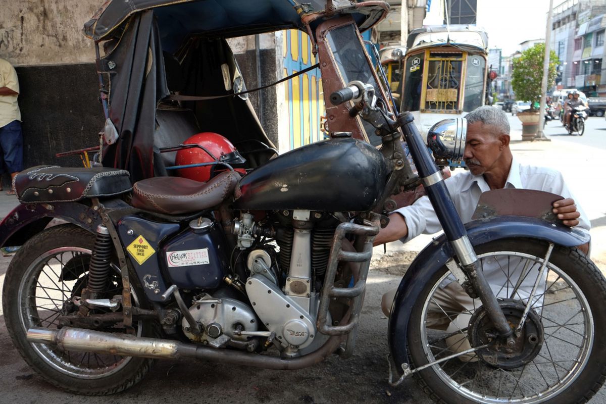 Pengemudi becak memeriksa kondisi becak motornya, di Pematang Siantar, Sumatera Utara, Minggu (29/10). Becak yang digerakkan dengan motor Birmingham Small Arms (BSA) tersebut adalah kendaraan sisa perang dunia kedua dan menjadi alat transportasi khas Kota Pematang Siantar. ANTARA FOTO/Irsan Mulyadi/pd/17.