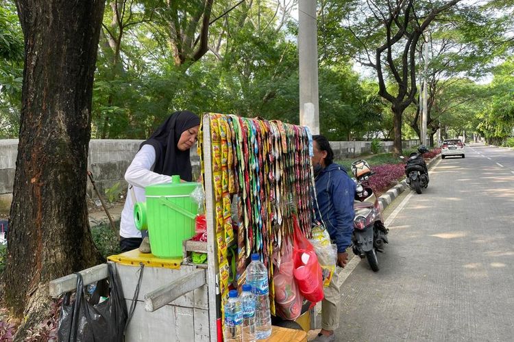 Pedagang Kaki Lima bernama Yulyanti (43) saat berdagang di pinggir Jalan R.E. Martadinata, dekat Gerbang Tol Ancol Timur, Pademangan, Jakarta Utara. 