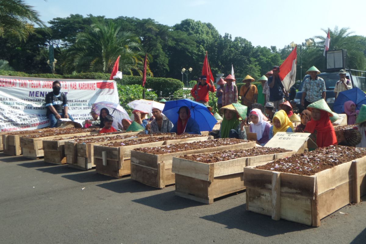 Aksi kubur diri petani Telukjambe di depan Halaman Monumen Nasional, Jakarta Pusat, Senin (1/5/2017)
