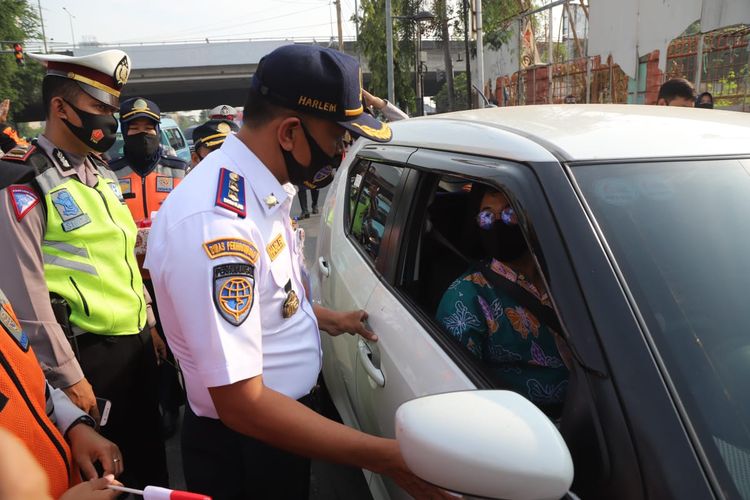 Petugas mensosialisasikan penerapan kembaki sistem ganjil-genap di ruas Jalan Gunung Sahari, Jakarta Utara 