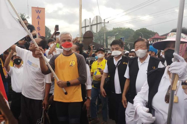 Gubernur Jawa Tengah Ganjar Pranowo saat mengawai prosesi jalan kaki atau kirab umat Buddha pada rangkaian perayaan Tri Suci Waisak 2566 BE, di Candi Mendut, Kabupaten Magelang, Jawa Tengah, Senin (16/5/2022).