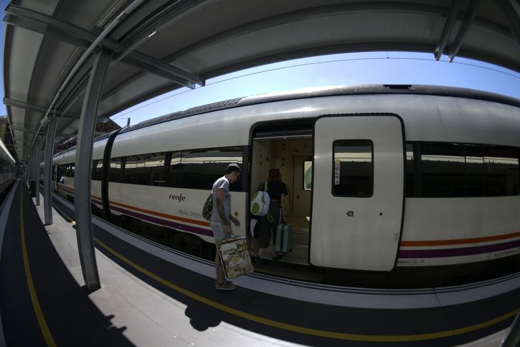 Ilustrasi seorang penumpang menaiki kereta yang dioperasikan Renfe di stasiun Madrid. (AFP/GABRIEL BOUYS)