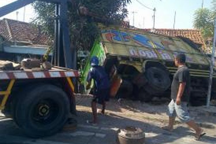 Truk muatan cabai yang terguling di jalur pantura Brebes, Jawa Tengah, diangkat oleh mobil derek, Sabtu (9/11/2013).