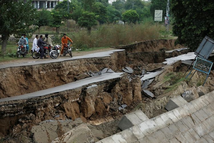 Warga menyaksikan jalanan yang rusak akibat gempa dangkal yang mengguncang kota Mirpur di Pakistan, pada Selasa (24/9/2019).