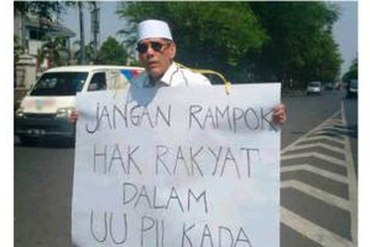Mantan anggota DPRD dan aktivis di Solo, Jawa Tengah, menggelar aksi tunggal di Bundaran Gladag, Jalan Slamet Riyadi pada hari Senin (8/9/2014), menentang pemilihan kepala daerah oleh DPRD.