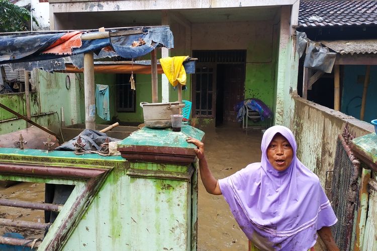 Erlina (47), warga RT 001/RW 008 Pondok Gede Permai, Jatiasih, Bekasi seharian bertahan di atap rumah ketika banjir menerjang rumahnya pada Rabu (1/1/2020).