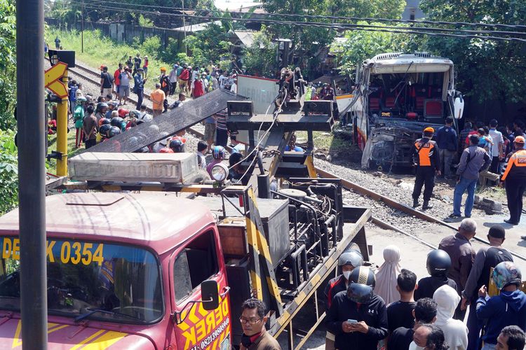 Suasana evakuasi bangkai bus pariwisata PO Harapan Jaya yang tertabrak KA Rapih Doho di perlintasan kereta api tanpa palang pintu di Desa Ketanon, Tulungagung, Jawa Timur, Minggu (27/2/2022). Kecelakaan yang terjadi sekitar pukul 05.00 WIB itu menyebabkan lima dari 43 penumpang termasuk awak bus meninggal dunia dan 14 lainnya luka-luka dan harus dilarikan ke RSUD dr. Iskak Tulungagung untuk mendapat pertolongan kedaruratan medis.