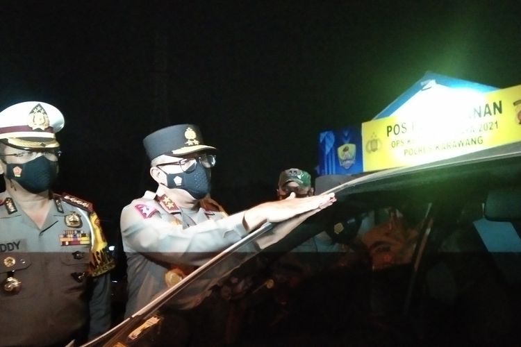 Kakorlantas Polri Irjen Pol Istiono didampingi Dirlantas Polda Jabar Kombes Pol Eddy Djunaedi menempelkan stiker pada mobil pemudik yang telah mengikuti rapid test antigen di Rest Area Kilometer 62 tol Jakarta-Cikampek arah menuju Jakarta, Minggu (16/5/2021).