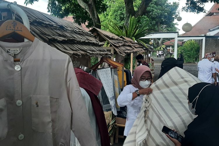 Seorang pengunjung melihat kain tenun khas Osing bermotif Solok hasil produksi mesin, yang dikembangkan desainer pakaian Sanet Sabintang, di sebuah pameran UMKM, di Pendopo Kabupaten Banyuwangi, Sabtu (19/3/2022).