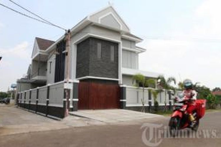 Warga melintas di depan rumah pribadi milik Ketua Mahkamah Konstitusi (MK) nonaktif, Akil Mochtar di Jalan Karya Baru, Kelurahan Parit Tokaya, Kecamatan Pontianak Selatan, Kota Pontianak, Kalimantan Barat, Selasa (8/10/2013).