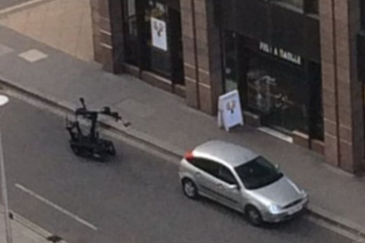 Robot penjinak bom mendekati mobil mencurigakan yang terparkir di jalanan kota London.