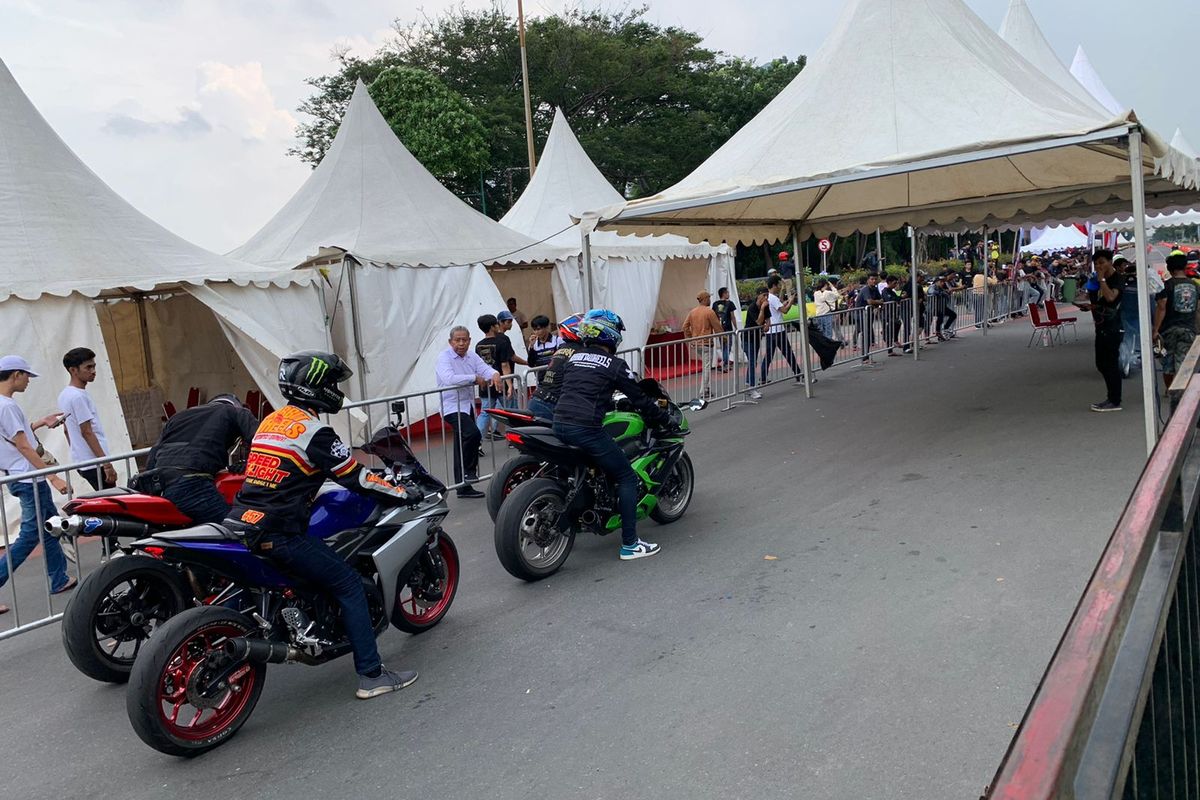 Peserta bersiap-siap untuk menjajal kecepatan sepeda motornya di lintasan balap sepanjang 500 meter di acara pre-event street race Kemayoran, Jalan H Benyamin Sueb, Kemayoran, Jakarta Pusat, Minggu (18/12/2022).