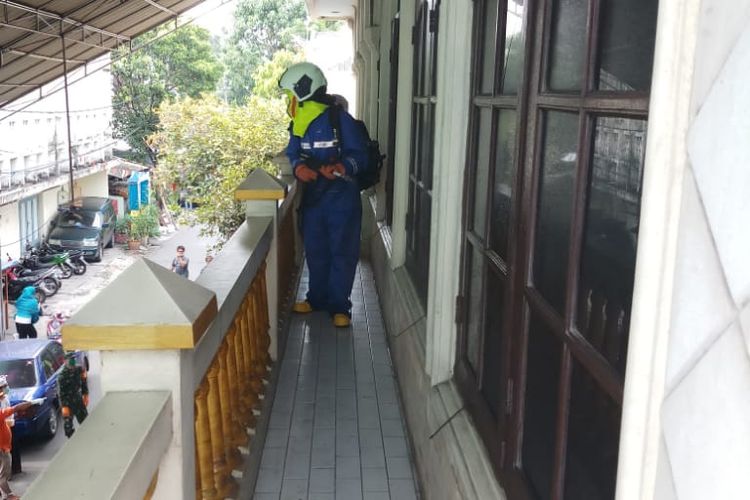 Petugas Gulkamart yang melakukan penyemprotan disinfektan di salah satu rumah warga  