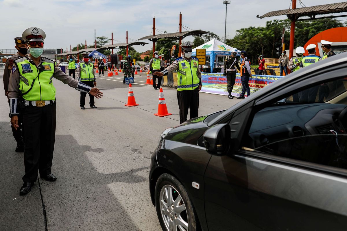 Petugas gabungan memeriksa kendaraan di gerbang tol Cikupa, Kabupaten Tangerang, Banten, Kamis (28/5/2020). Selama operasi pemeriksaan kepada masyarakat dari luar Jabodetabek yang ingin masuk ke Jakarta diharuskan menunjukkan SIKM, berdasarkan peraturan gubernur (Pergub) Nomor 47 Tahun 2020 yang mewajibkan membawa SIKM sebagai syarat memasuki wilayah Jakarta.