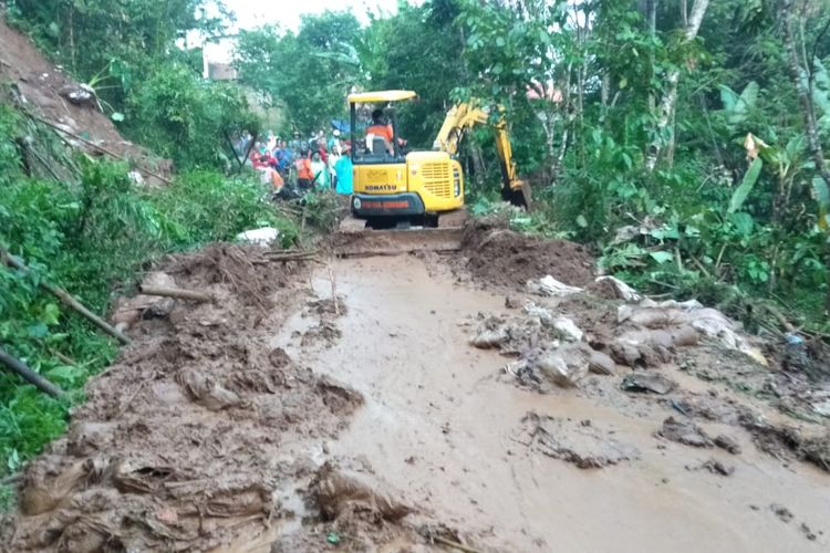 Alat berat BPBD Kabupaten Semarang membersihkan material longsor yang menutup jalan desa.