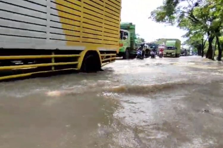 Petugas Kepolisian Sektor Klangenan, Polresta Cirebon Jawa Barat, mengatur arus lalulintas yang tersendat akibat digenangi banjir pada Rabu (6/3/2024) siang.