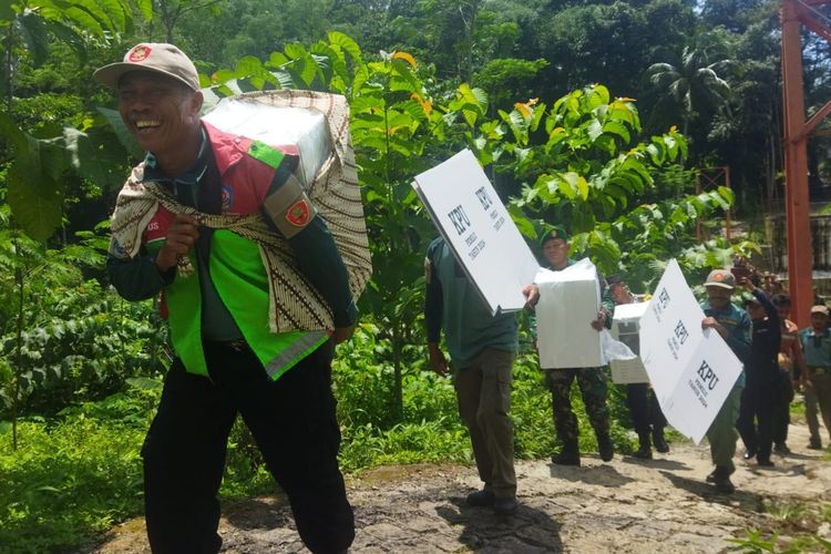 Petugas berjalan kaki mengirimkan logistik pemilu ke Dusun Cibun, Desa Sunyalangu, Kecamatan Karanglewas, Kabupaten Banyumas, Jawa Tengah, Selasa (13/2/2024).