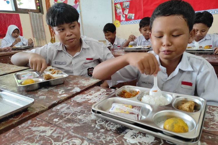 Pelajar SD Negeri Cangkringrembang, Kabupaten Demak menikmati makan bergizi gratis usai dibagikan pada Senin (24/2/2025).