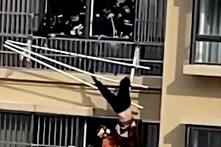 Petugas pemadam kebakaran China menyelamatkan seorang wanita tua yang jatuh setelah terpeleset dari tepi balkon dan tersangkut di jemuran baju.
