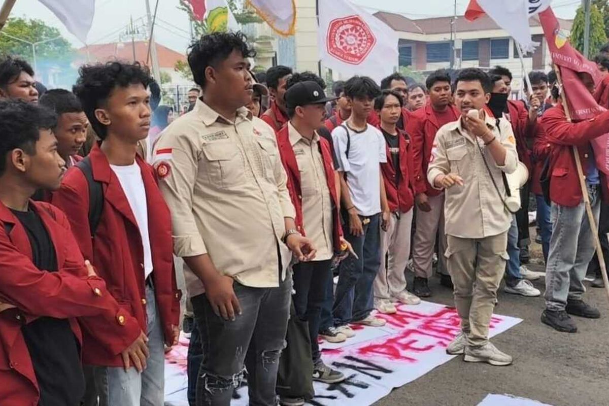 Gymnastiar Presiden BEM UMC Cirebon (memegang pengeras suara) berorasi di depan DPRD Kabupaten Cirebon, Kamis (9/1/2025) siang. Mereka menuntut pemerintah mencabut kenaikan PPN 12 persen, dan menetapkan pajak khusus orang kaya.