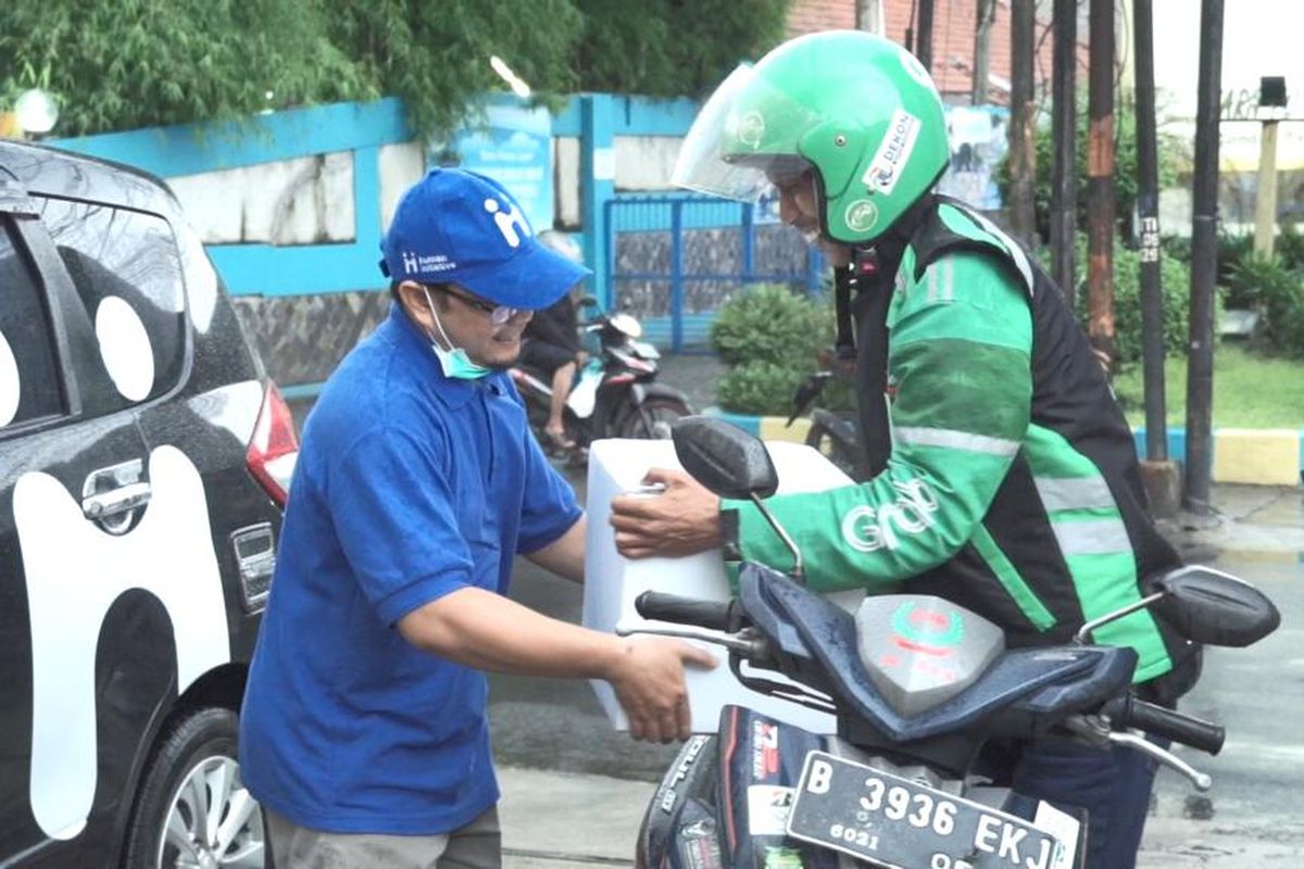 Pengendara ojek online menerima paket makanan, multivitamin dan hand sanitizer 