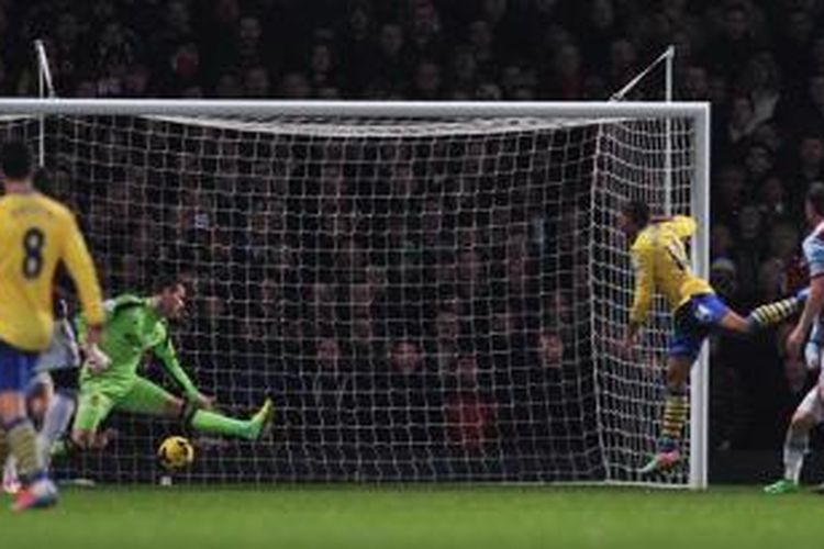 Pemain Arsenal, Theo Walcott (Kuning, 14) melepaskan sundulan yang gagal diantisipasi oleh kiper West Ham United, Adrian (hijau), pada laga Premier League, di di Stadion Boleyn, Kamis (26/12/2013).