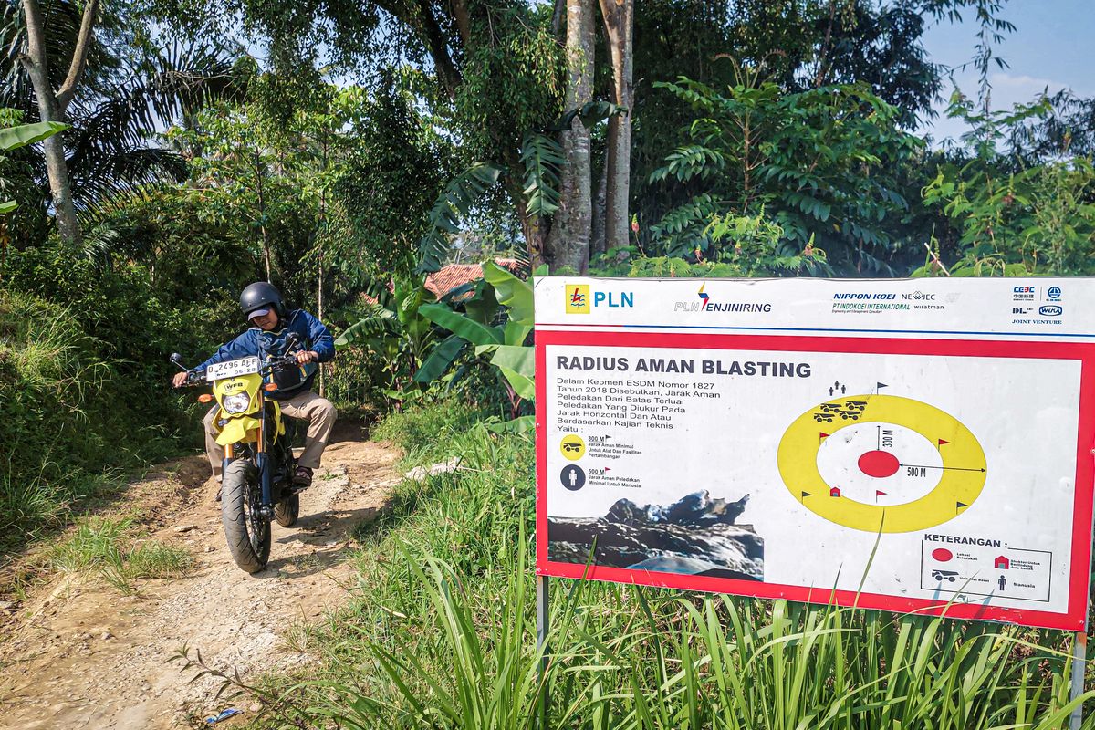 Seorang warga melintas jalan di belakang proyek pertambangan Gunung Karang, Desa Karangsari, Kecamatan Cipongkor, Kabupaten Bandung Barat (KBB), Jawa Barat, Rabu (30/4/2025).