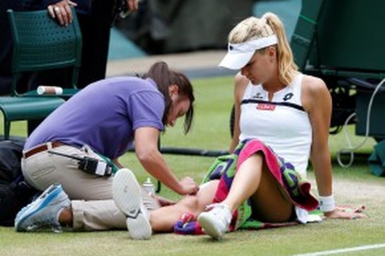 Petenis Polandia, Agnieszka Radwanska, mendapat perawatan medis setelah menyelesaikan set kedua pada babak perempat final turnamen Grand Slam Wimbledon, melawan Li Na dari China, Selasa (2/7/2013).