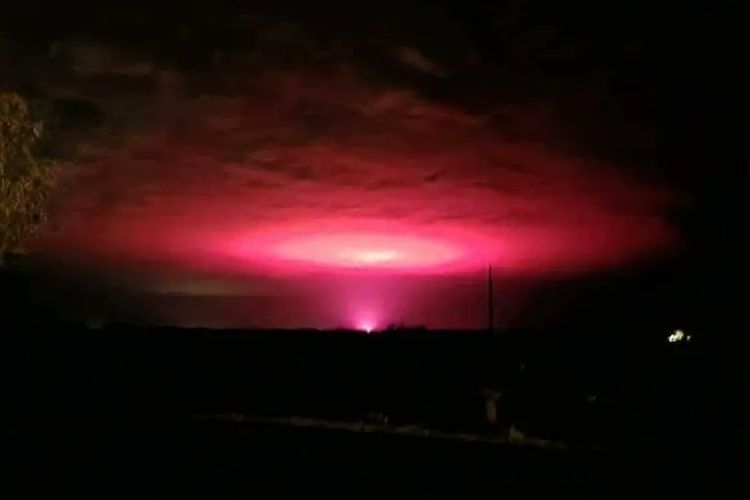 Cahaya merah muda misteriusmenerangi langit malam di atas sebuah kota Australia pada Rabu (20/7/2022).
