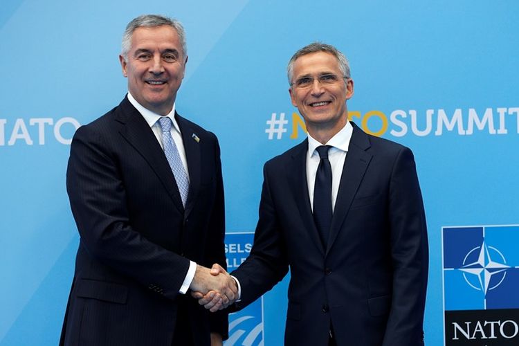 Presiden Montenegro Milo Djukanovic (kiri) berjabat tangan dengan Sekjen NATO Jens Stoltenberg (kanan) saat pertemuan NATO di Brussels, 11 Juli 2018.