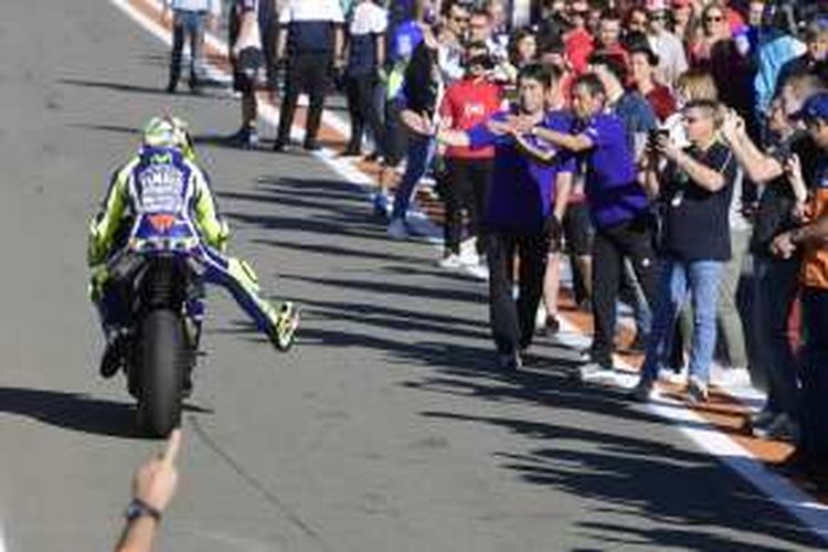 Pebalap Movistar Yamaha MotoGP asal Italia, Valentino Rossi, tiba di pit lane setelah menyelesaikan balapan GP Valencia di Sirkuit Ricardo Tormo, Minggu (13/11/2016).