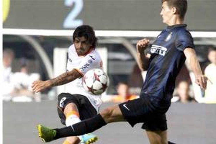 Pemain Valencia, Ever Banega (kiri), melepaskan tendangan keras melewati pemain Inter Milan Marco Andreolli, dalam pertandingan persahabatan bertajuk International Champions Cup di MetLife stadium di East Rutherford, New Jersey, Minggu (4/8/2013). Banega cetak satu gol dan Valencia menang 4-0.