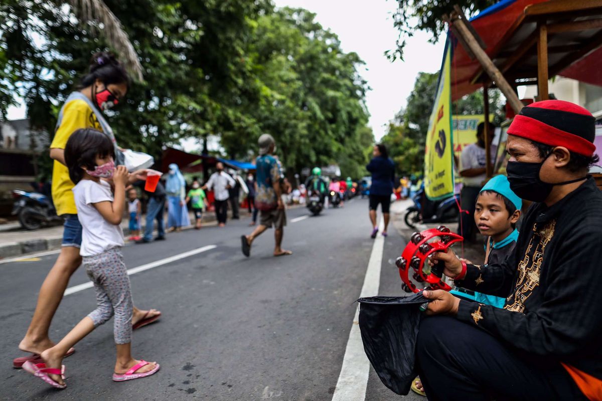 Warga mengantre untuk mendapatkan takjil dengan menjaga jarak di Jl. Cempaka Warna RT 05 RW 06, Cempaka Putih Timur, Jakarta Timur, Kamis (21/5/2020). Setiap hari selama Ramadan, relawan dan donatur membagikan 400 hingga 600 takjil kepada warga kurang mampu dan terdampak virus corona COVID-19.