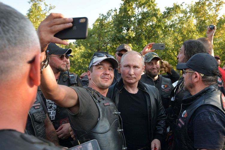 Presiden Rusia Vladimir Putin ketika selfie bersama seorang anggota geng motor Night Wolves ketika datang dalam acara hari jadi mereka di Sevastopol, Crimea. Kunjungan itu terjadi tengah aksi unjuk rasa yang menentang Putin.