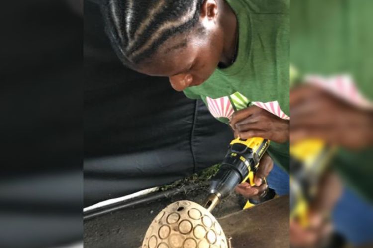 Salah satu warga Merauke yang tengah membuat kancing baju dari batok kelapa