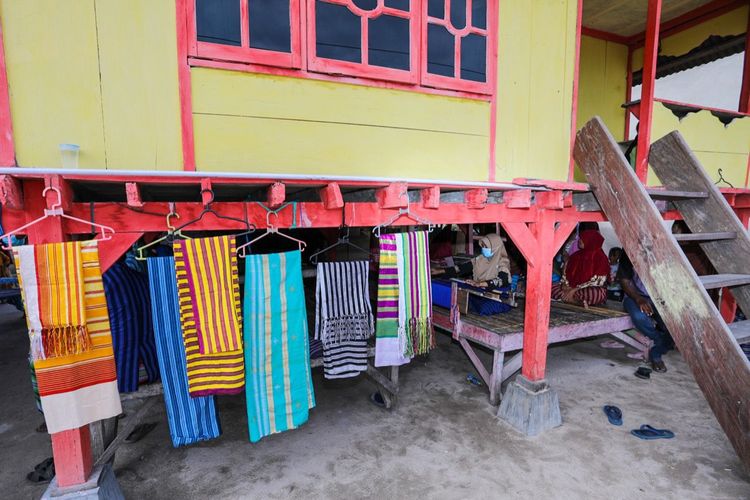 Sejumlah perempuan menenun di baawah rumah Desa Gumananon, Kecamatan Mawasangka, Buton Tengah. Sulawesi Tenggara. Desa Gumananon menjadi tempat warisan leluhur turun temurun terkait tenun Kamohu. 