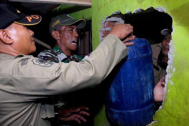 Petugas menyita minuman keras (miras) ilegal dari sebuah tempat yang dijadikan penyimpanan di daerah Cicalengka, Kabupaten Bandung, Jawa Barat, Minggu (8/4/2018). Korban miras jenis oplosan di daerah tersebut terus bertambah, dari data terakhir sebanyak 23 orang dilaporkan tewas dengan indikasi keracunan.