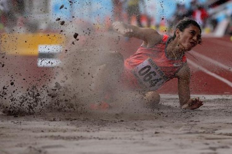 Atlet putri asal Bali, Maria Natalia Londa bertanding saat final  lompat jangkit putri PON XIX di Stadion Pakansari, Cibinong, Jawa Barat, Minggu (25/9/2016).  Ia meraih emas dengan hasil lompatan 13.52 meter.