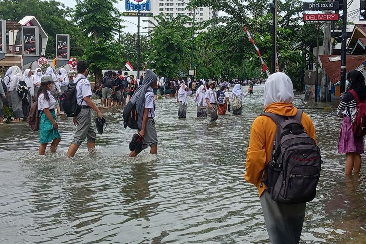 Sejumlah pelajar sekolah dan warga di lokasi terjadinya banjir di Jalan Dr Mansyur, Medan, Kelurahan Selayang I, Kecamatan Medan Selayang pada Kamis (18/8/2022).
