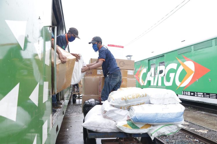 Beberapa petugas tengah memasukkan barang ke dalam Rail Express.