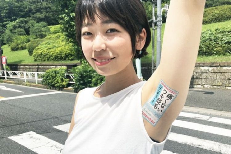 Seorang model berjalan sambil menunjukkan ketiaknya yang berisi iklan sebuah produk. Perusahaan Jepang menggunakan ketiak untuk memasang iklan produk kliennya.