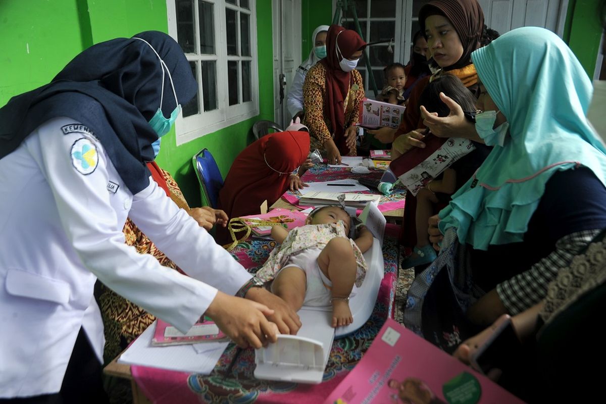 Petugas kesehatan menimbang berat badan bayi di Posyandu Delima 33, Palembang, Sumatera Selatan, Rabu (24/3/2021). Mulai tahun 2021 Kegiatan Posyandu di Kota Palembang kembali dirutinkan bagi masyarakat luas dengan menerapkan protokol kesehatan. ANTARA FOTO/Feny Selly/wsj.