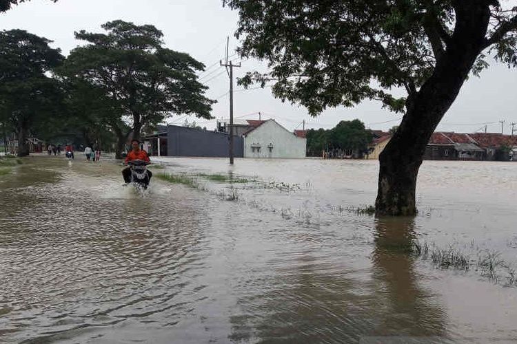 Pengendara sepeda motor yang memaksa melewati jalur Arjawinangun ke Panguragan terendam banjir, Senin (18/1/2021). 