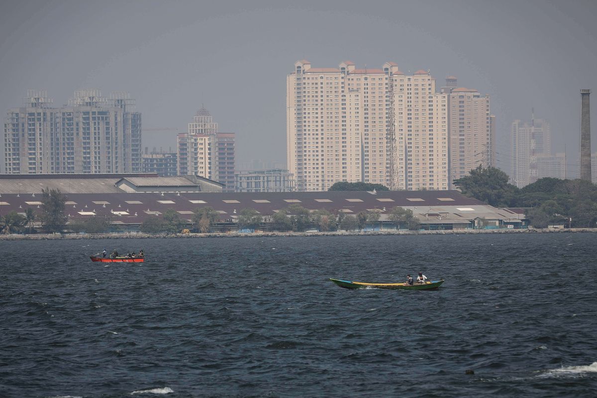 Pemandangan laut dengan latar belakang gedung bertingkat yang diselimuti asap polusi di Jakarta Utara, Rabu (31/7/2019). Berdasarkan data situs penyedia peta polusi daring harian kota-kota besar di dunia AirVisual, menempatkan Jakarta pada urutan pertama kota terpolusi sedunia pada Senin (29/7) pagi dengan kualitas udara mencapai 183 atau dalam kategori tidak sehat.